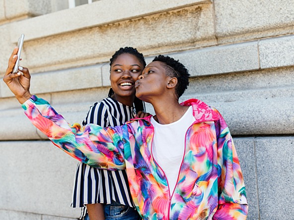 Two women of colour taking a selfie, representing the LGBTQ+ community